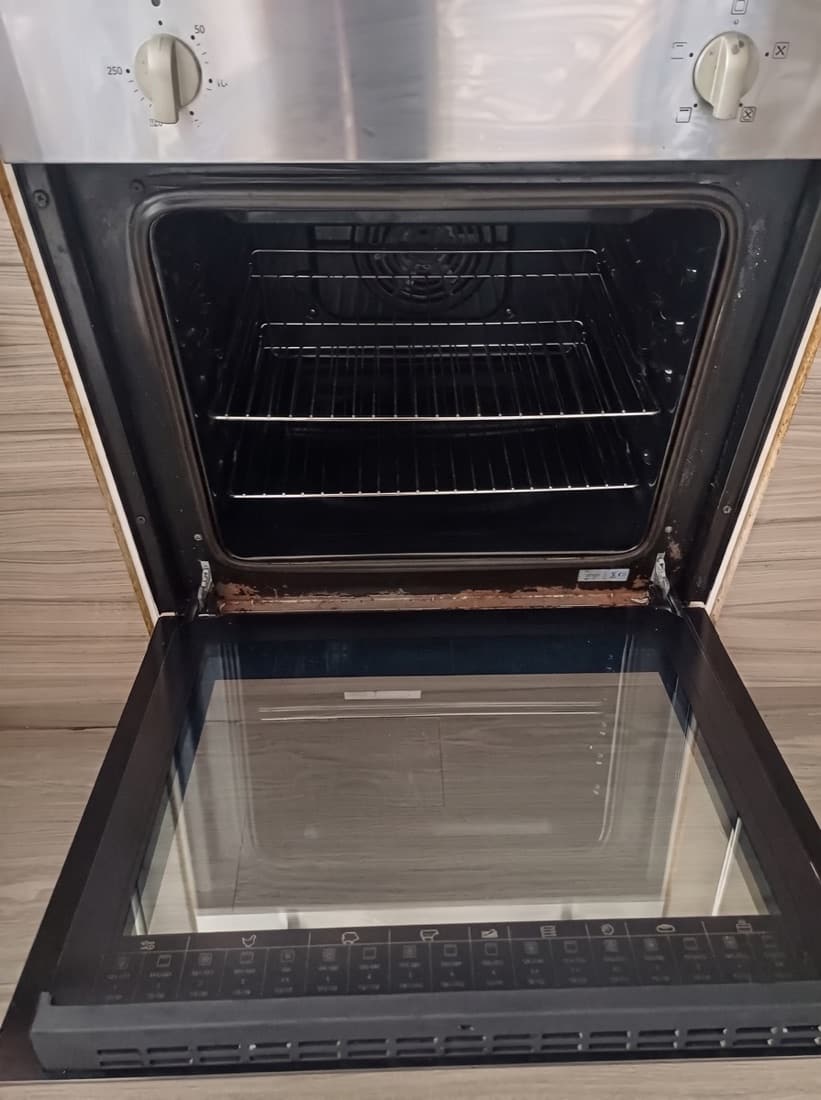 Oven before cleaning — burnt-on grease around the door seal and frame