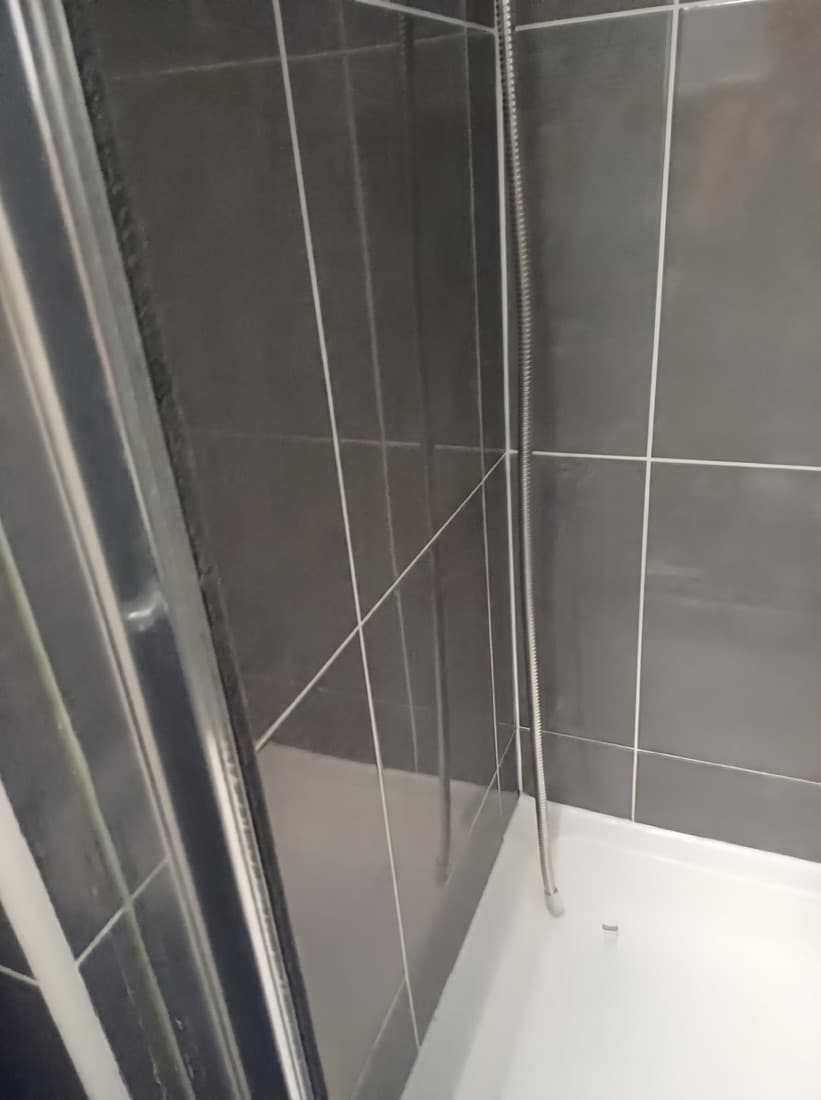 The same shower cubicle after our deep clean — clean tiles, grout and tray